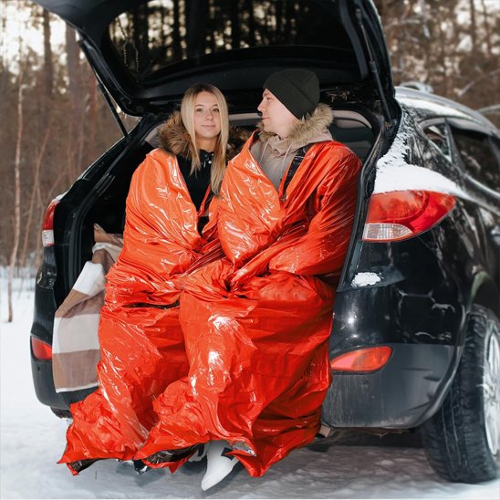 Couple assis voiture sac de couchage d'urgence