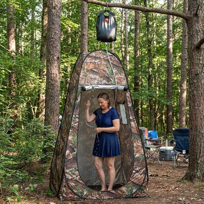 Femme debout tente de douche camouflage